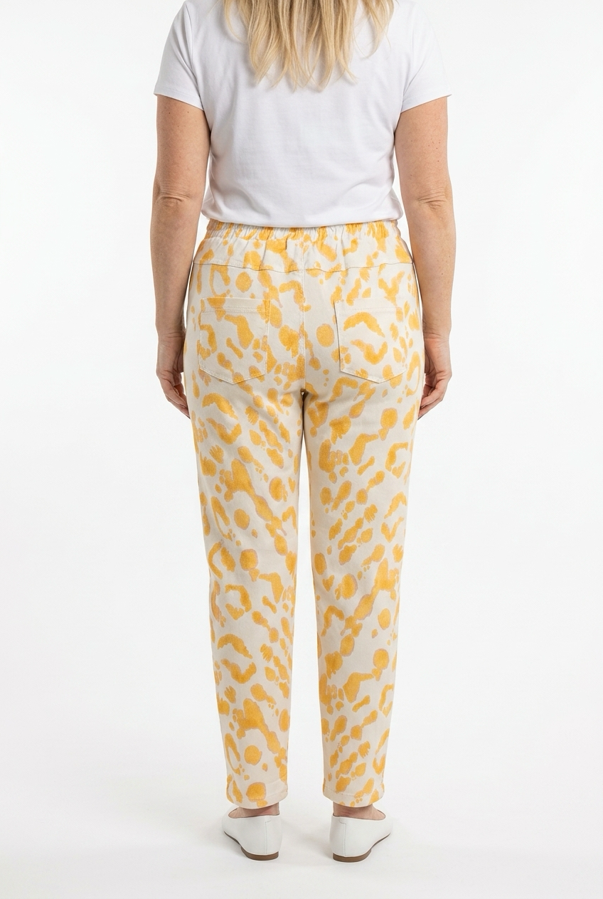 vaaleat joggerit naisen päällä, joissa keltaisia kuvioita. Housuissa takataskut.