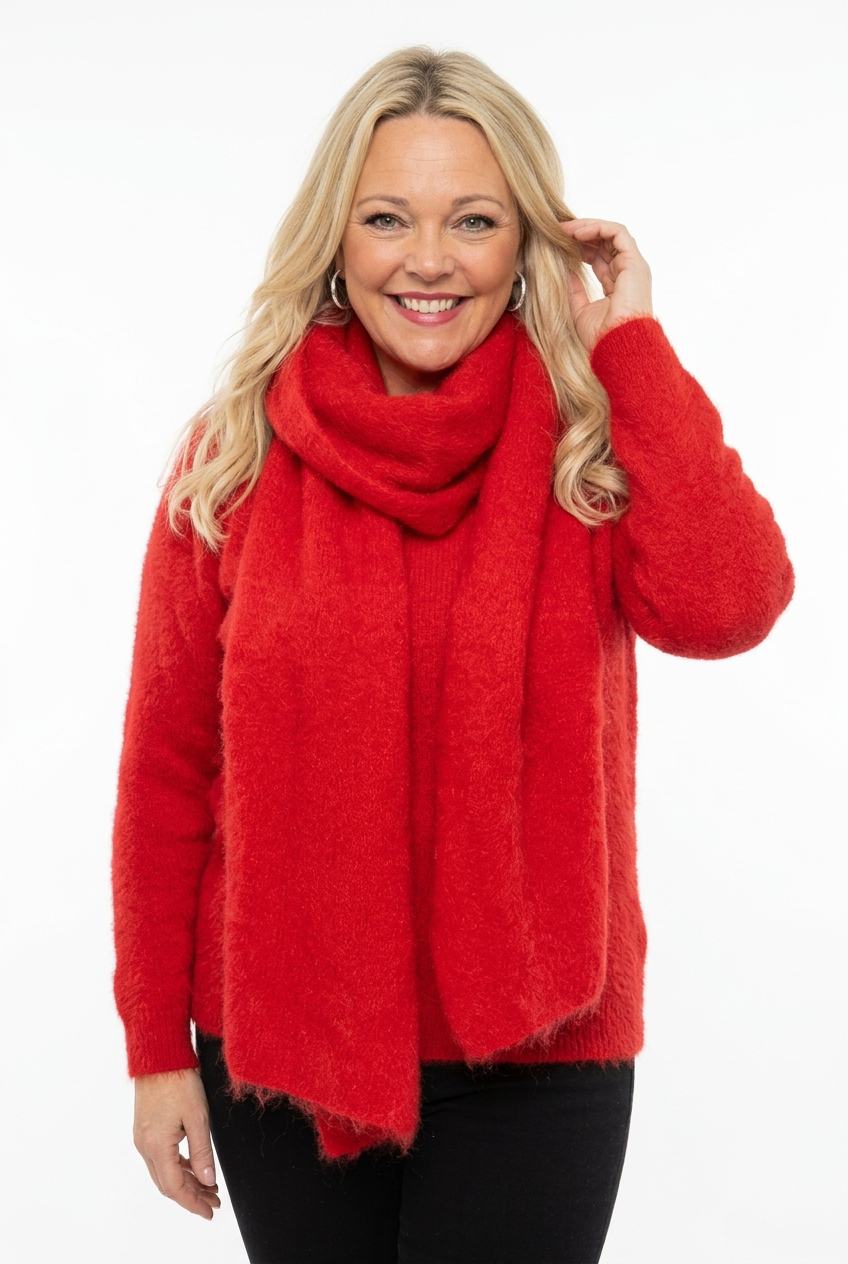 naisen kaulalla punainen, iso ja muhkea neulehuivi.