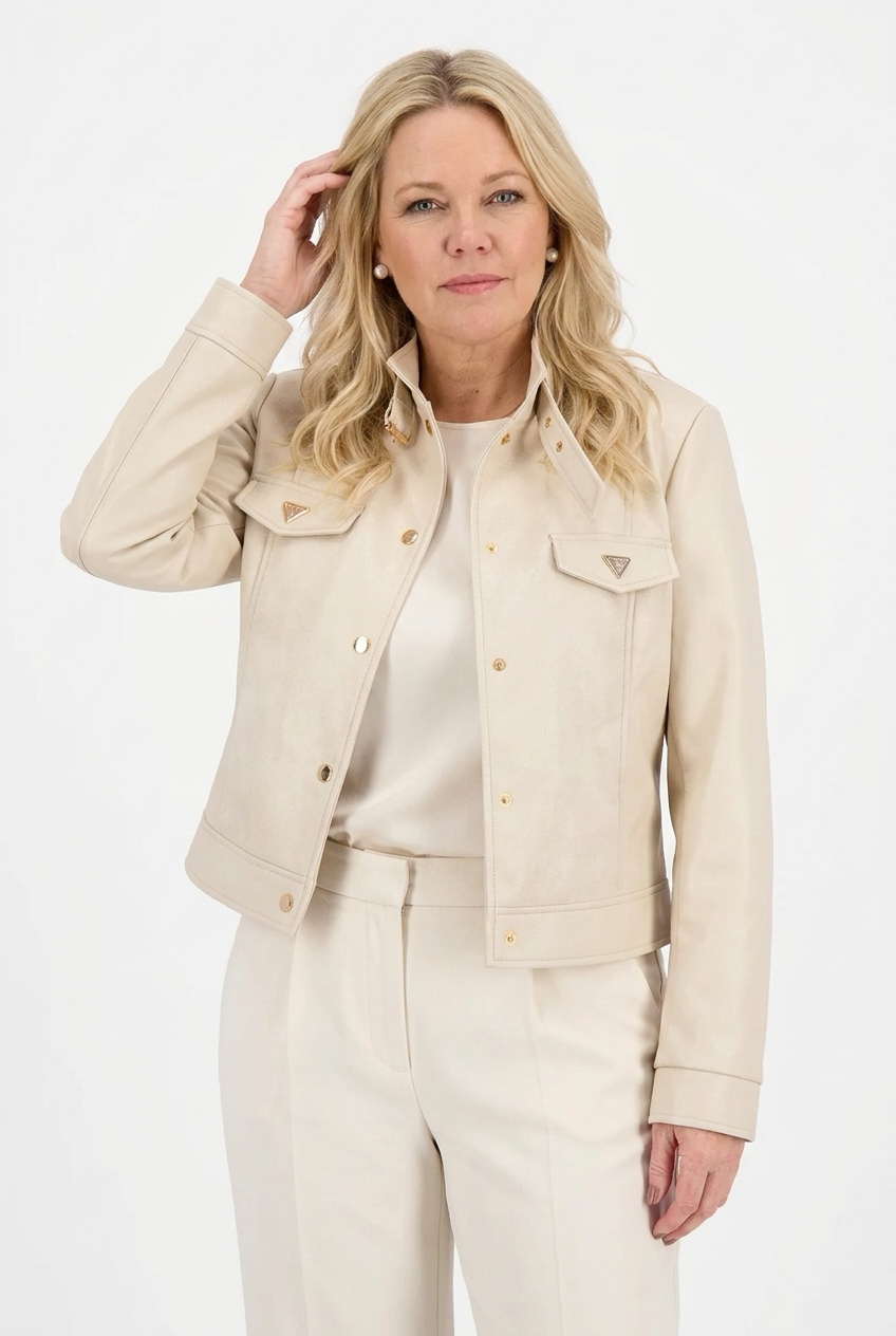 beige lyhyt nahkajakku naisen päällä, jossa pystykaulus, napit sekä taskunläpät edessä. 