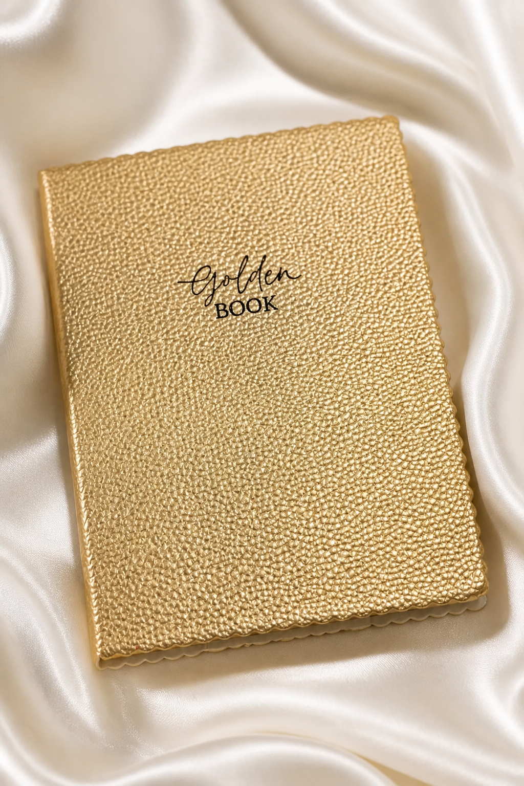 kullanvärinen muistikirja, jossa piparireunat ja musta golden book teksti.