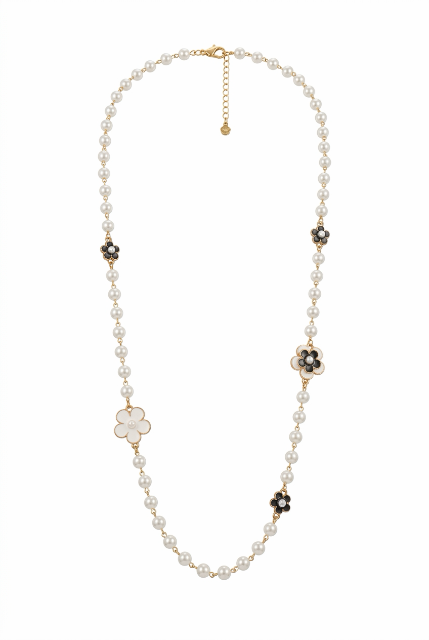 pitkä vaalea helmikaulakoru, jossa vaaleita ja mustia kukkia.