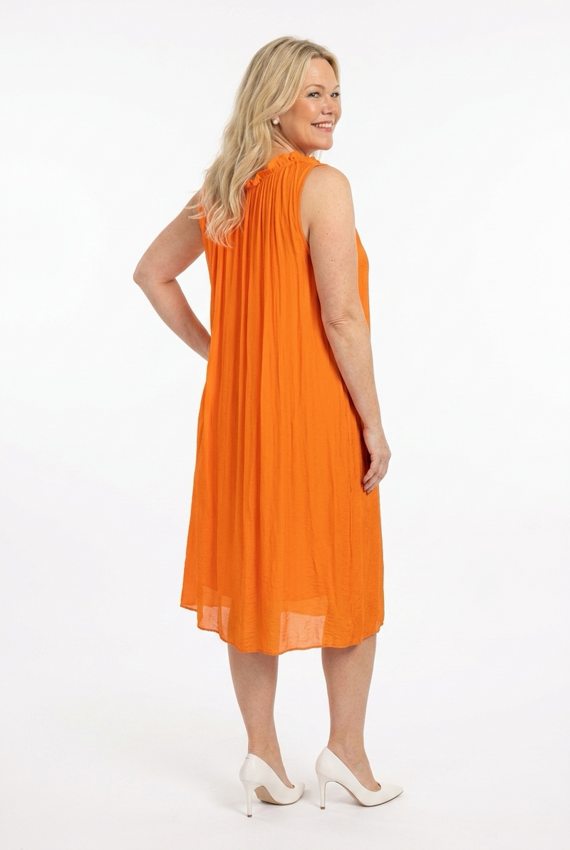 oranssi hihaton polvipituinen väljä mekko naisen päällä, jossa ylös tuleva o-pääntie ja olalla solmittavat nauhat.