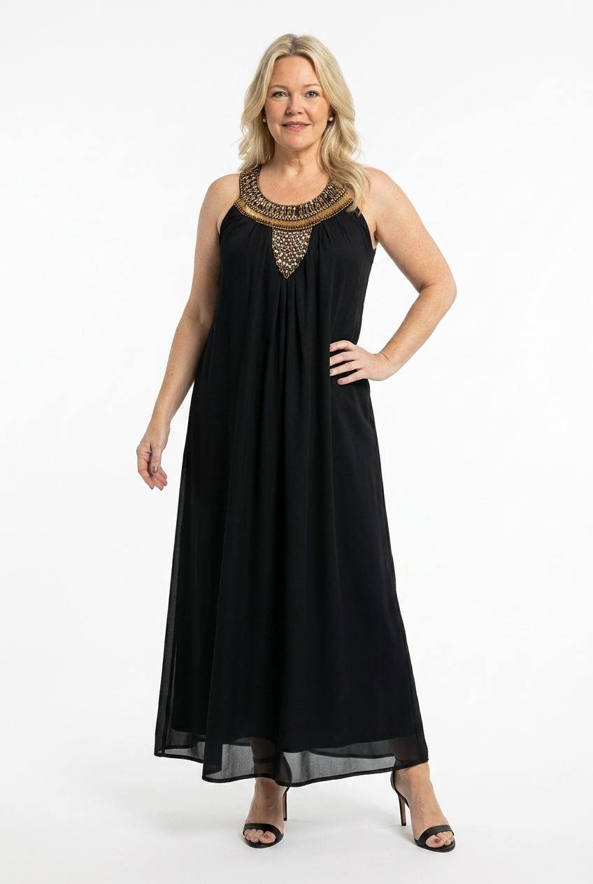 musta pitkä ja hihaton suoralinjainen mekko naisen päällä, jossa pääntiellä suuri korumainen koristelu.