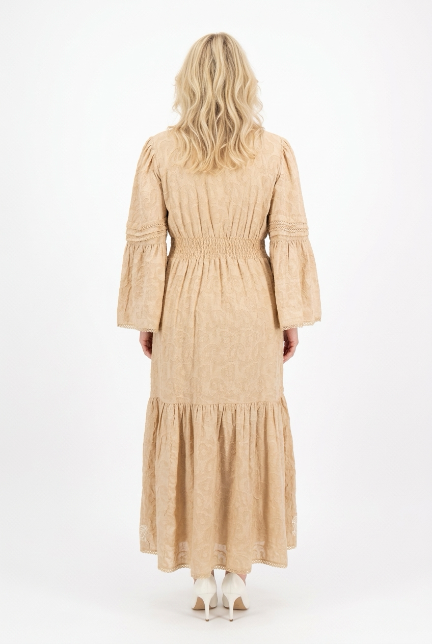 maxipituinen ja pitkähihainen beige mekko, jossa kapea vyötärö, levenevä helma sekä hihat. 