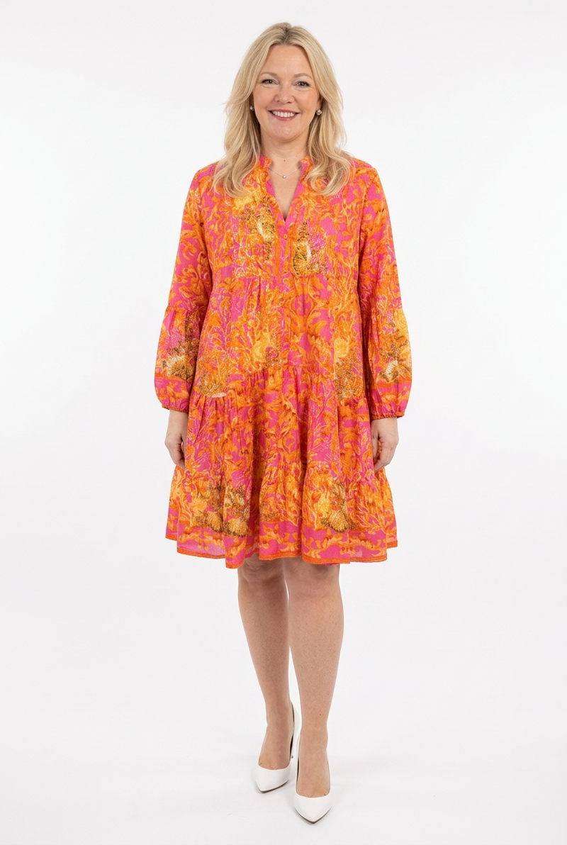 polvipituinen ja kellohelmainen oranssi-fuksia mekko, jossa v-pääntie a pitkät hihat naisen päällä.