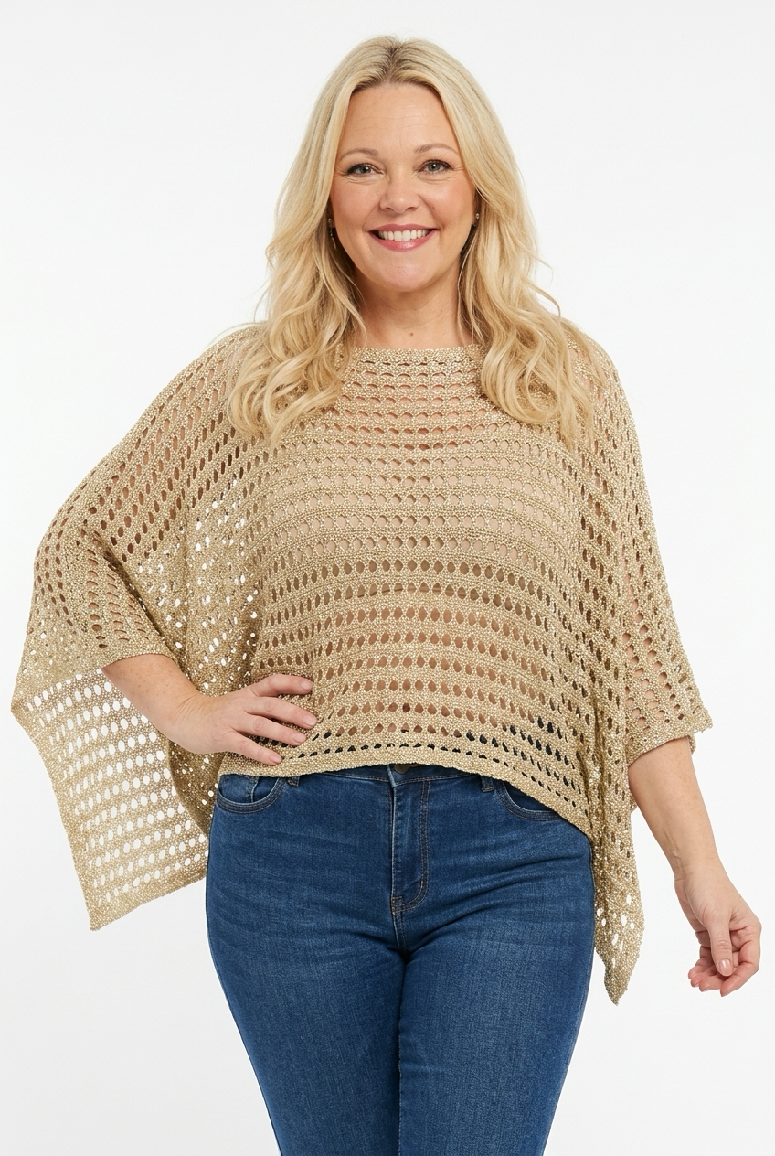 naisen päällä kullanbeige lyhyempi neuleponcho läpikuultavaa reikäneulosta.