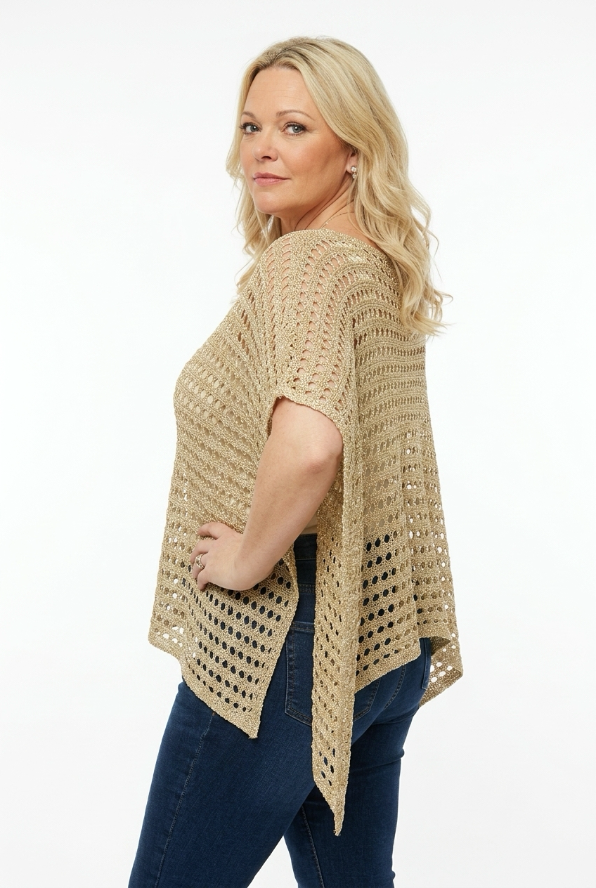 naisen päällä kullanbeige lyhyempi neuleponcho läpikuultavaa reikäneulosta.