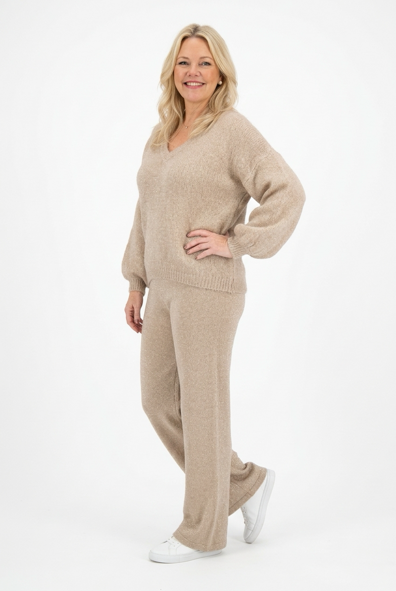 vaalea v-aukkoinen ja pitkähihainen neulepusero naisen päällä.