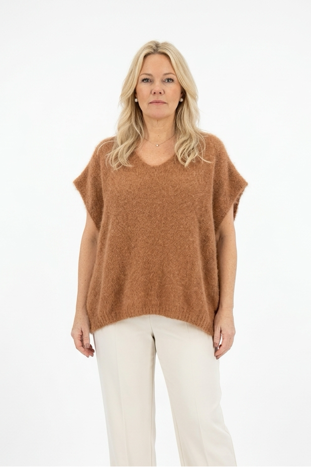 lyhyt kamelinvärinen reilu neulepusero, jossa v-pääntie naisen päällä.