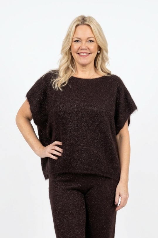 tummanruskea oversize mallinen neulepusero lyhyellä hihalla naisen päällä.