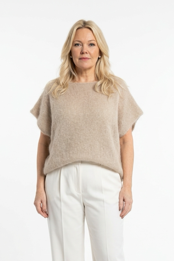 vaalea oversize mallinen neulepusero lyhyellä hihalla naisen päällä.