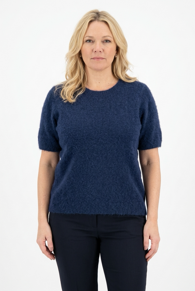 tummansininen, o-aukkoinen ja lyhythihainen neulepusero naisen päällä. Perusmalli.