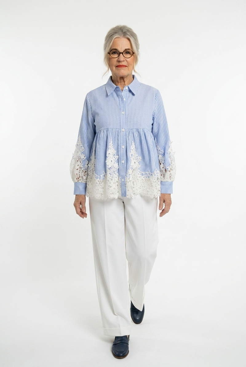 raidallinen sini-valkoinen lyhyt paitapusero, jossa helmassa ja hihansuussa reilut valkoiset pitsit. Puserossa pitkät hihat, kaulukset ja edessä napitus. Naisen päällä.