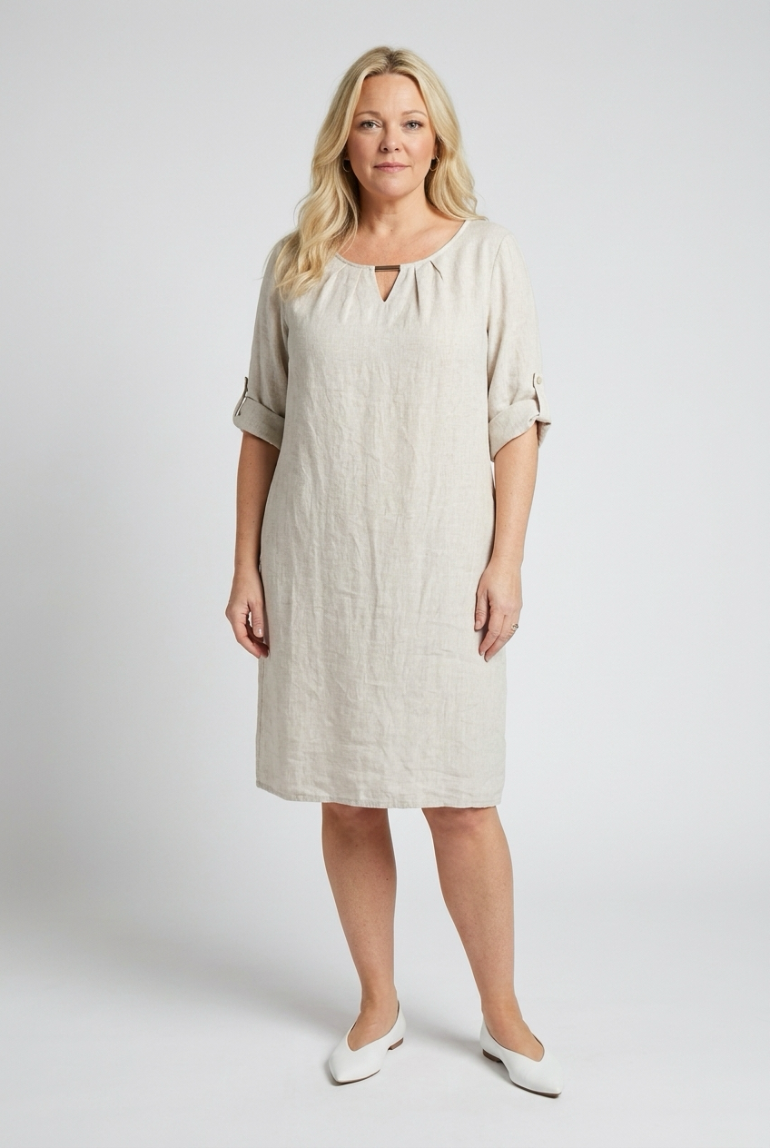 beige polvimittainen mekko naisen päällä, jossa käännetty hiha ja kolmio pääntiellä.