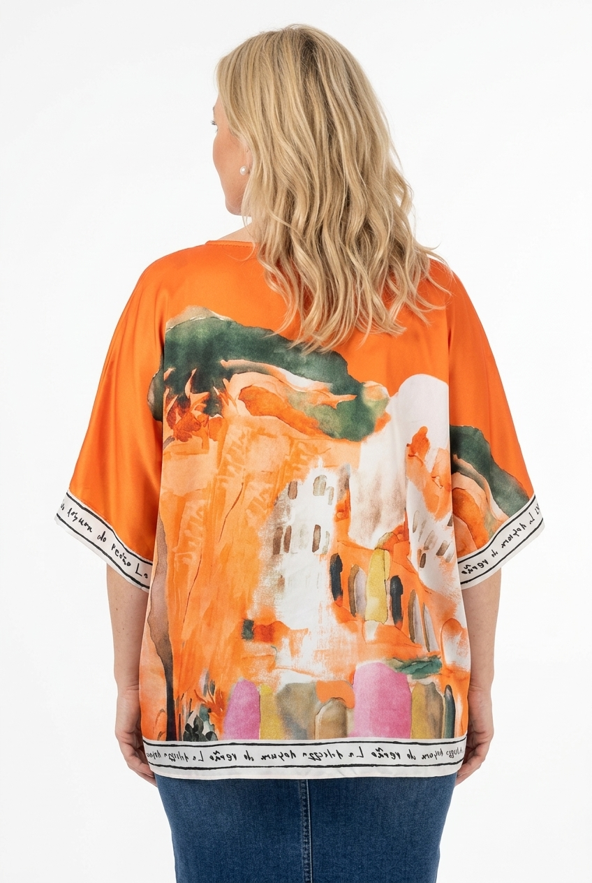oranssi oversize pusero, jossa vajaamittainen hiha ja o-aukko. Puserossa reilu maisemakuosimja tekstikanttaus hihansuussa ja helmassa.
