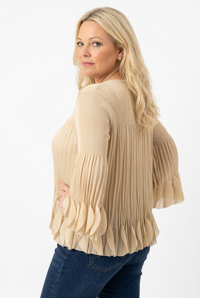 naisen päällä sivusta kuvattuna beige pliseerattu pusero, jossa o-pääntie, vajaamittainen hiha ja a-linjainen malli. Helmassa ja hihansuussa kolmiulotteisia kangaspyörylöitä.