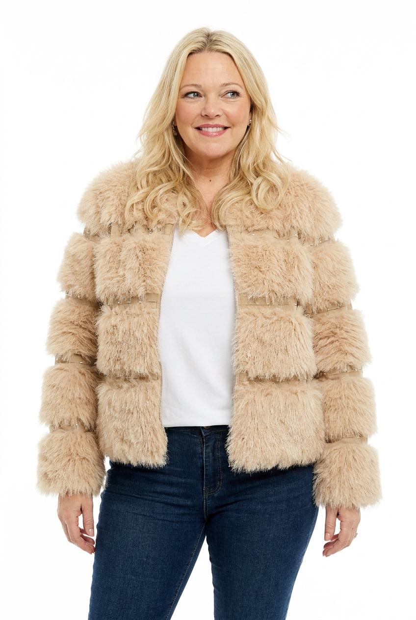 beige, lyhyt keinoturkkitakki naisen päällä. Takissa o-pääntie, pitkät hihat, edessä vetoketju ja koristenauhoja niiteillä poikkiraitoina.