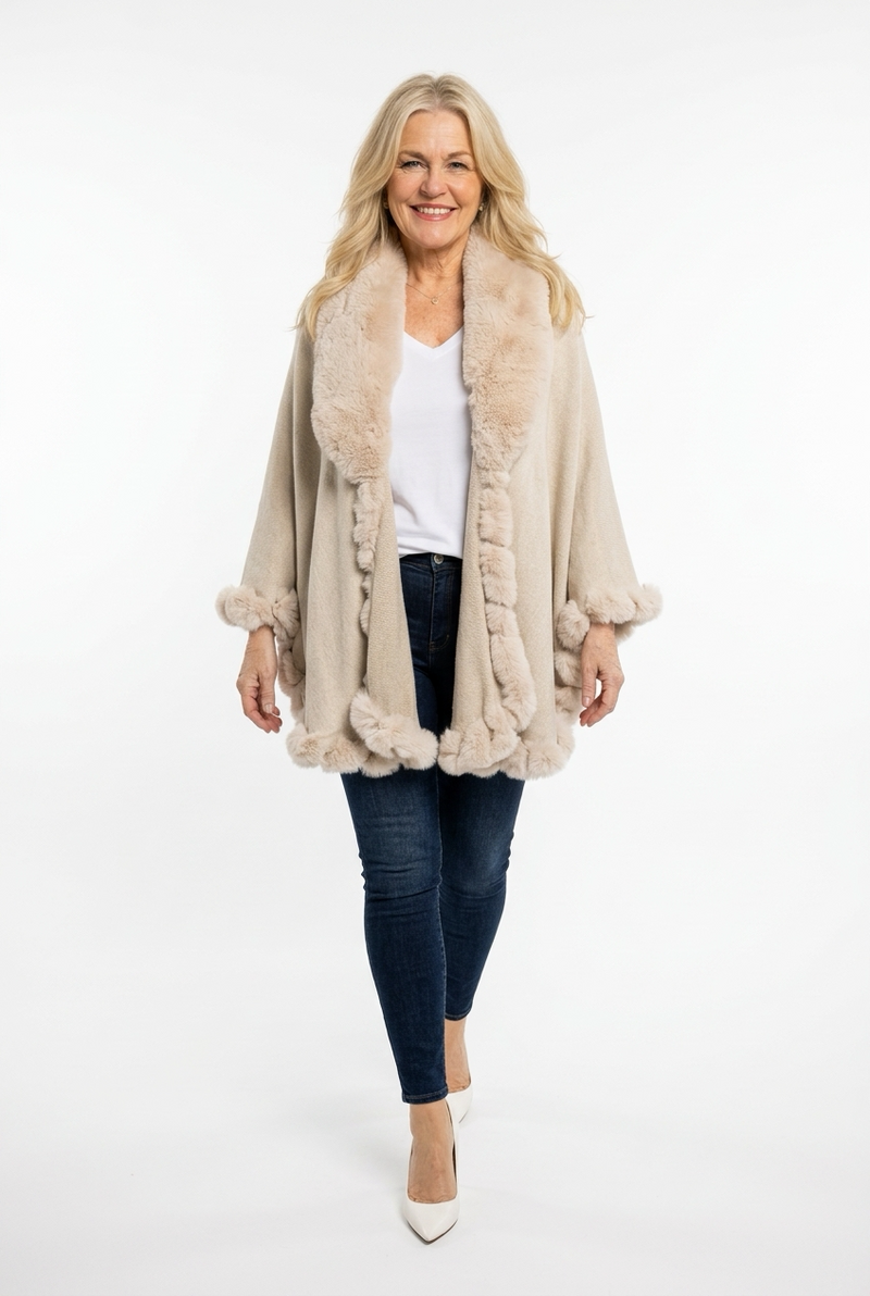 beige a-linjainen neuleviitta, jossa karvakaulus ja karvareunus naisen päällä